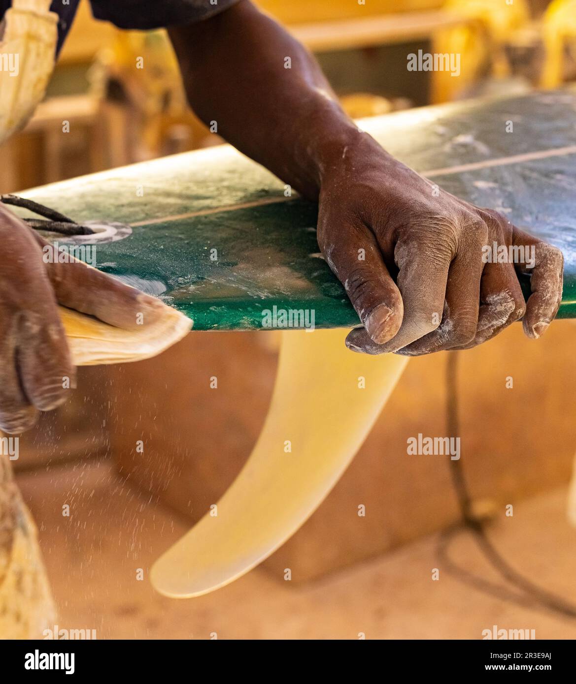 Un Shaper de surf de Craftsman africain travaillant dans un atelier de réparation Banque D'Images