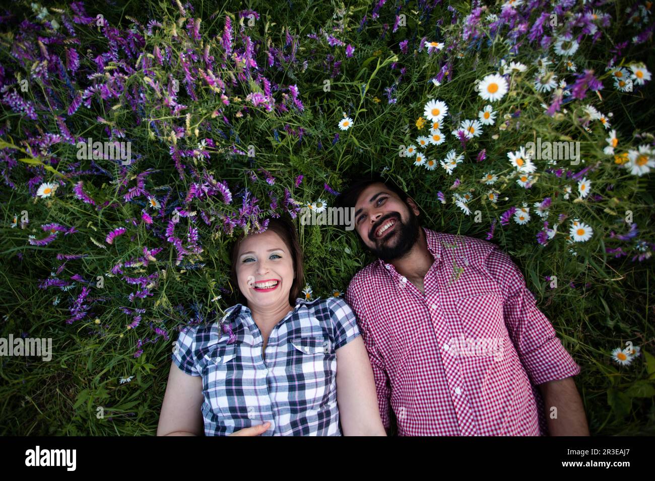 Couple romantique amour moment dans le champ parmi les fleurs sauvages Banque D'Images