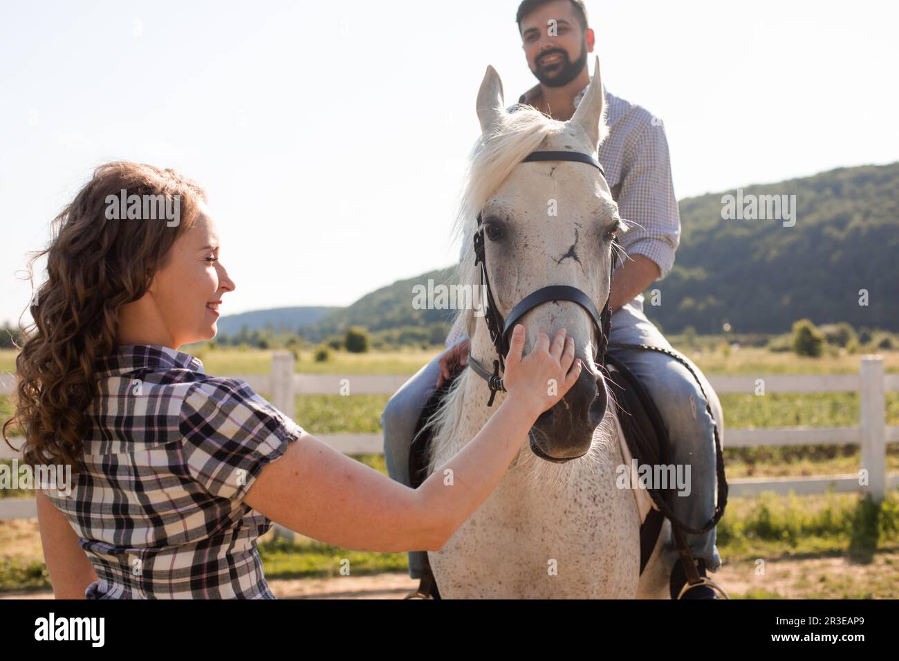 Le jeune couple se repose sur une ferme de chevaux Banque D'Images