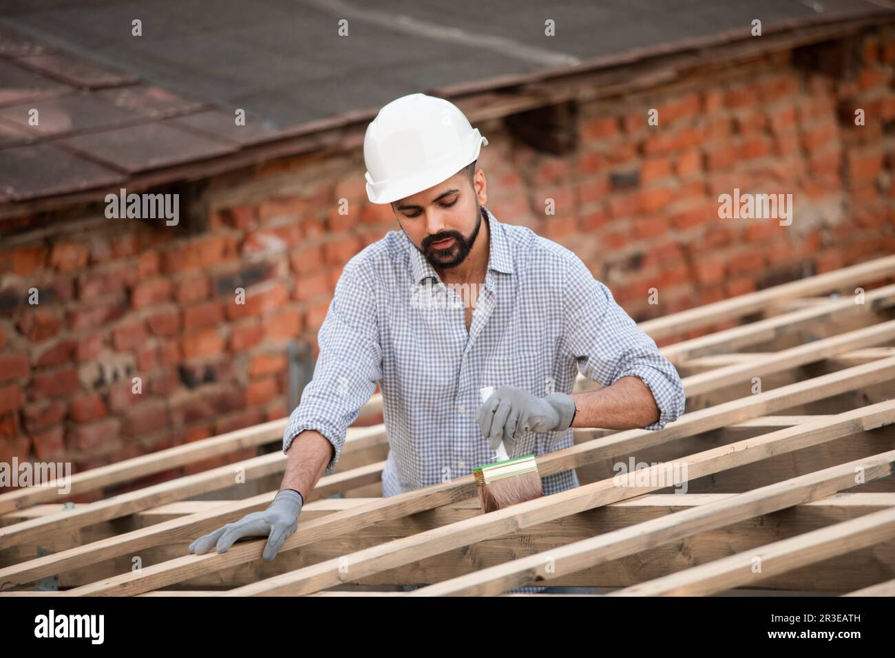 Le jeune constructeur travaille sur un toit non fini Banque D'Images