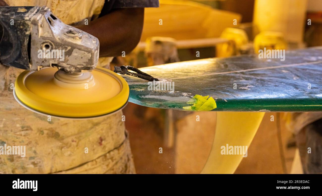 Un Shaper de surf de Craftsman africain travaillant dans un atelier de réparation Banque D'Images