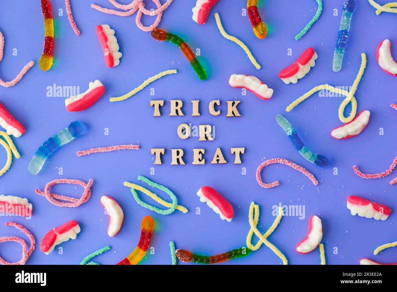 Concept Halloween. Décorations de fête d'Halloween avec des mots TRICK OU TRAITER, bonbons, vue du dessus plat sur fond bleu Banque D'Images