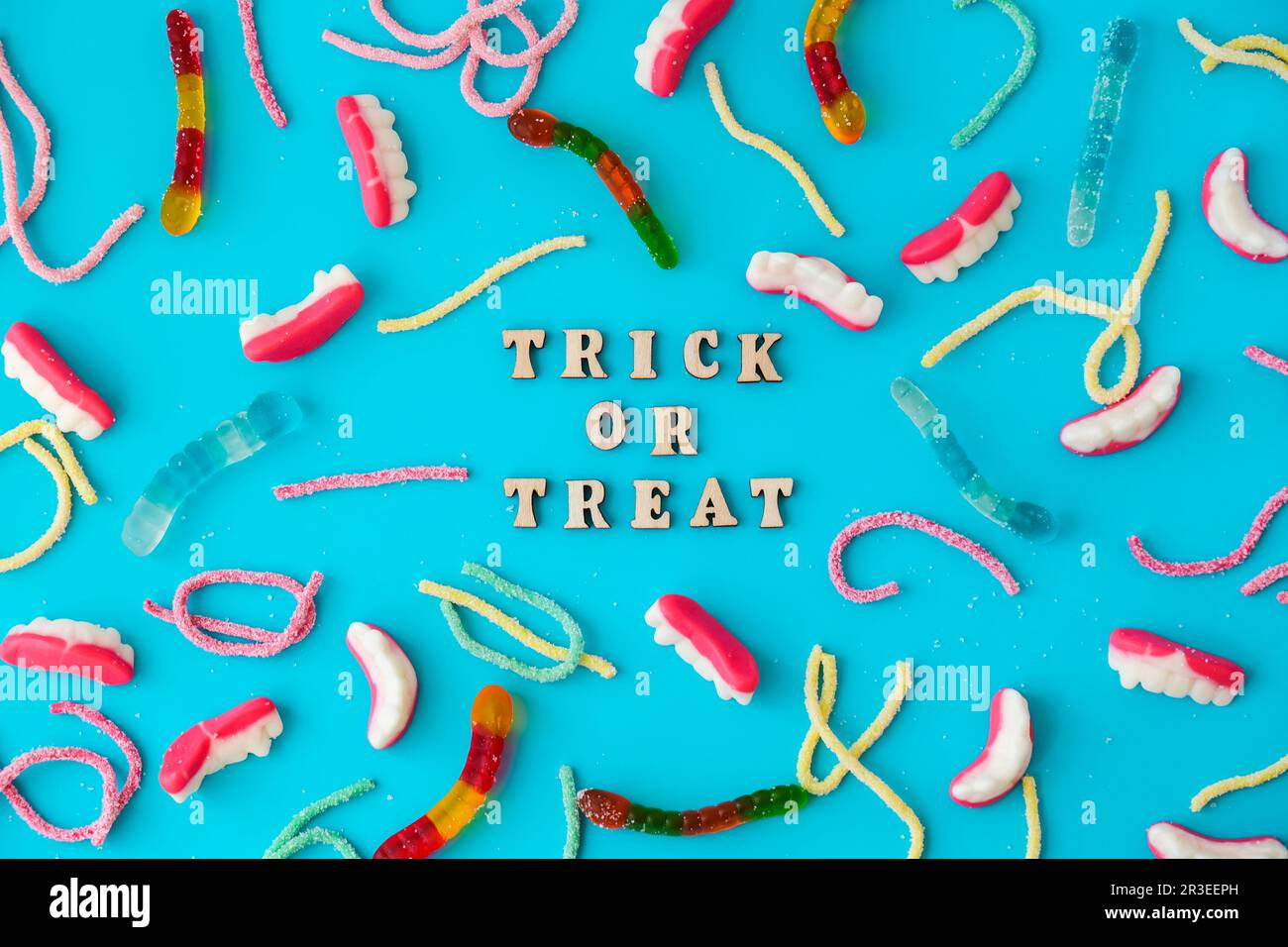 Concept Halloween. Décorations de fête d'Halloween avec des mots TRICK OU TRAITER, bonbons, vue du dessus plat sur fond bleu Banque D'Images