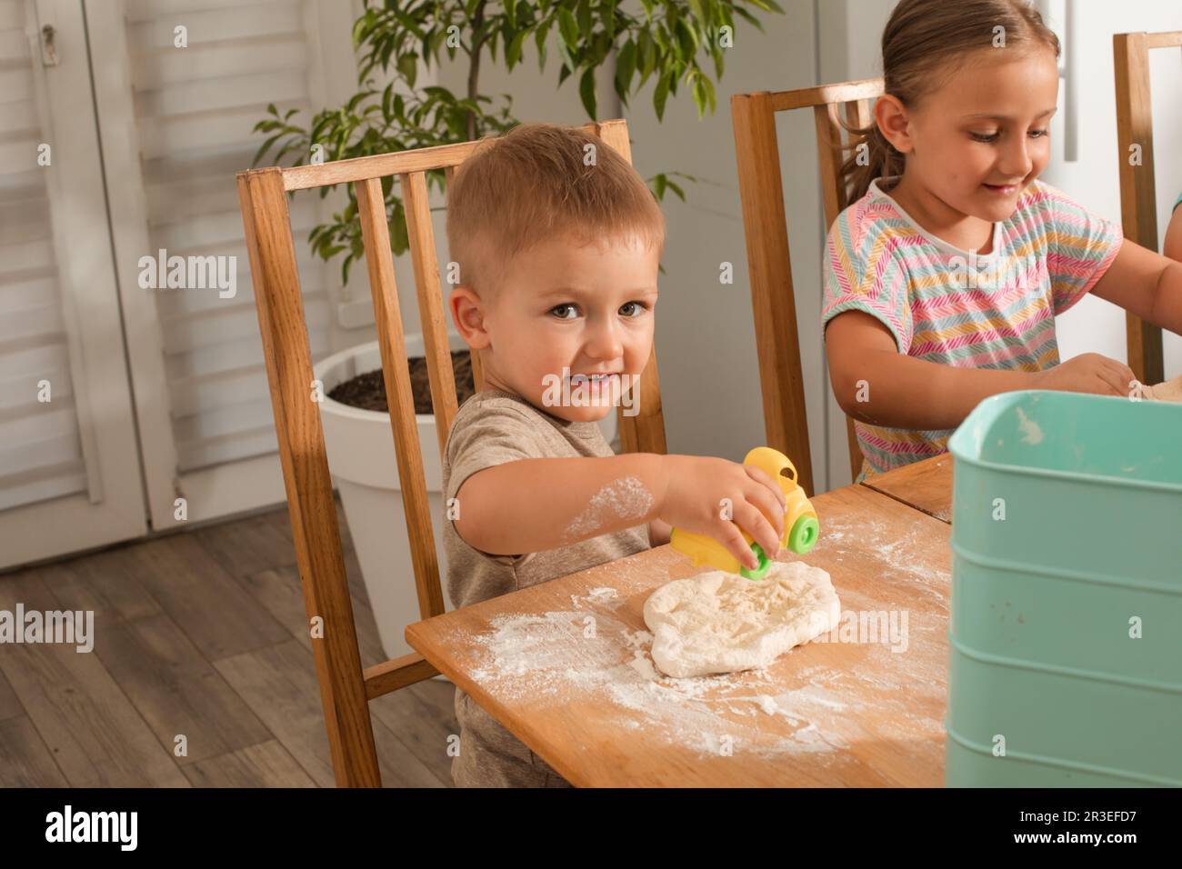 Le mignon petit garçon joue pendant la cuisson Banque D'Images