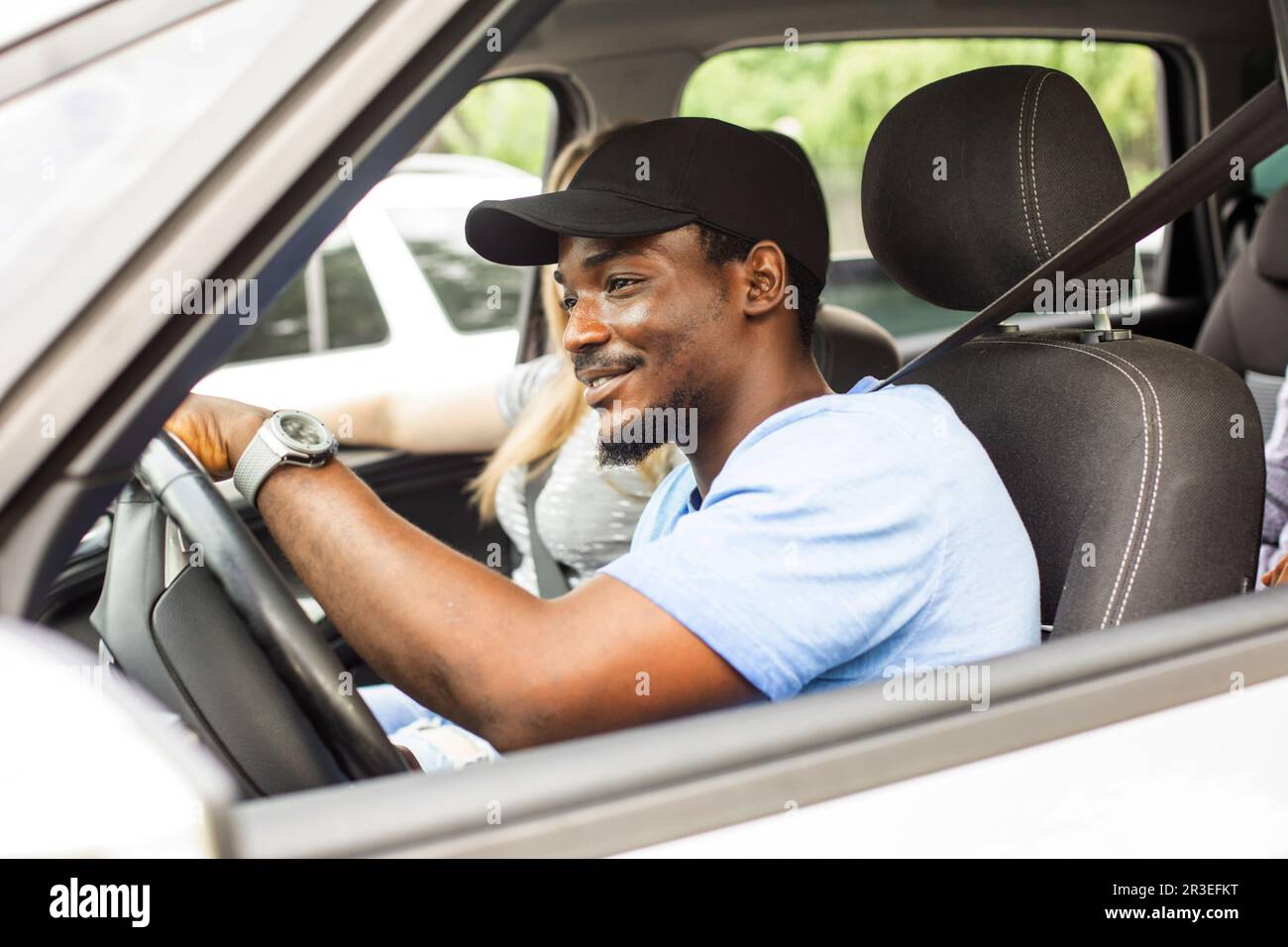 Joyeux jeune homme en voiture avec des amis en vacances Banque D'Images