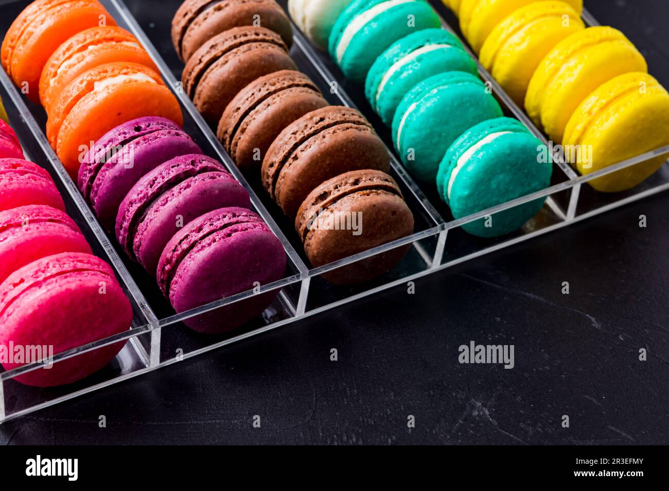 Biscuits aux macarons colorés dans la boîte en acrylique Banque D'Images