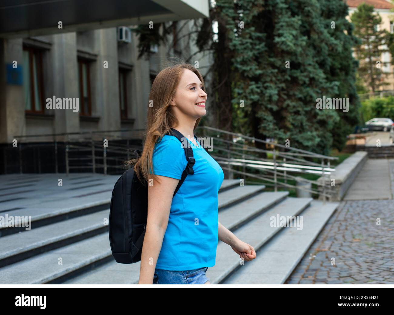 L'étudiante heureuse avec sac à dos quitte l'université Banque D'Images