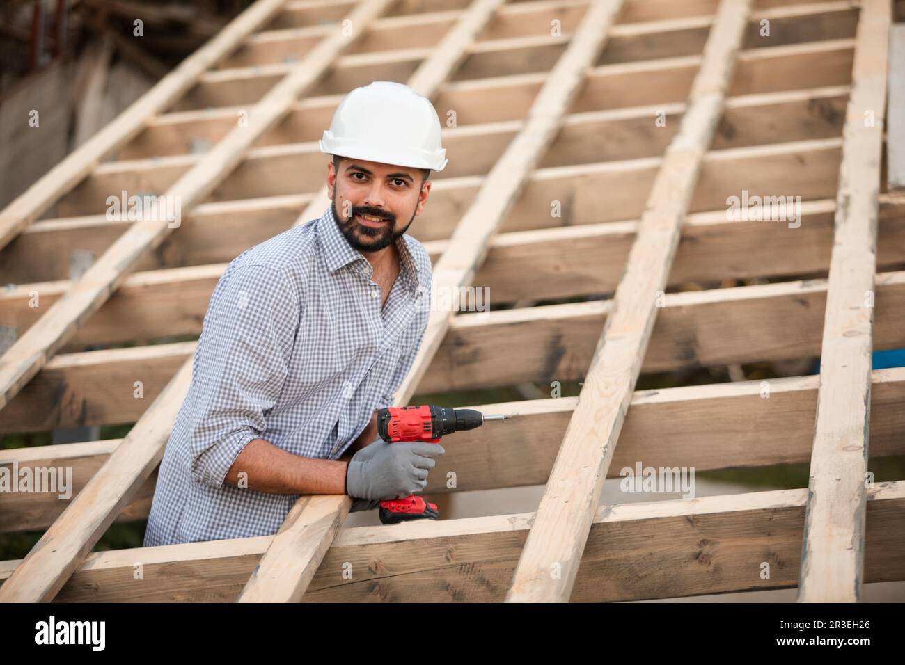 Le jeune constructeur travaille sur un toit non fini Banque D'Images