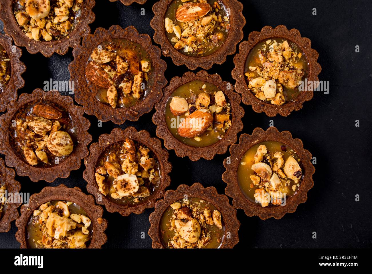 Délicieux tartalets au chocolat avec crème au caramel et noix Banque D'Images