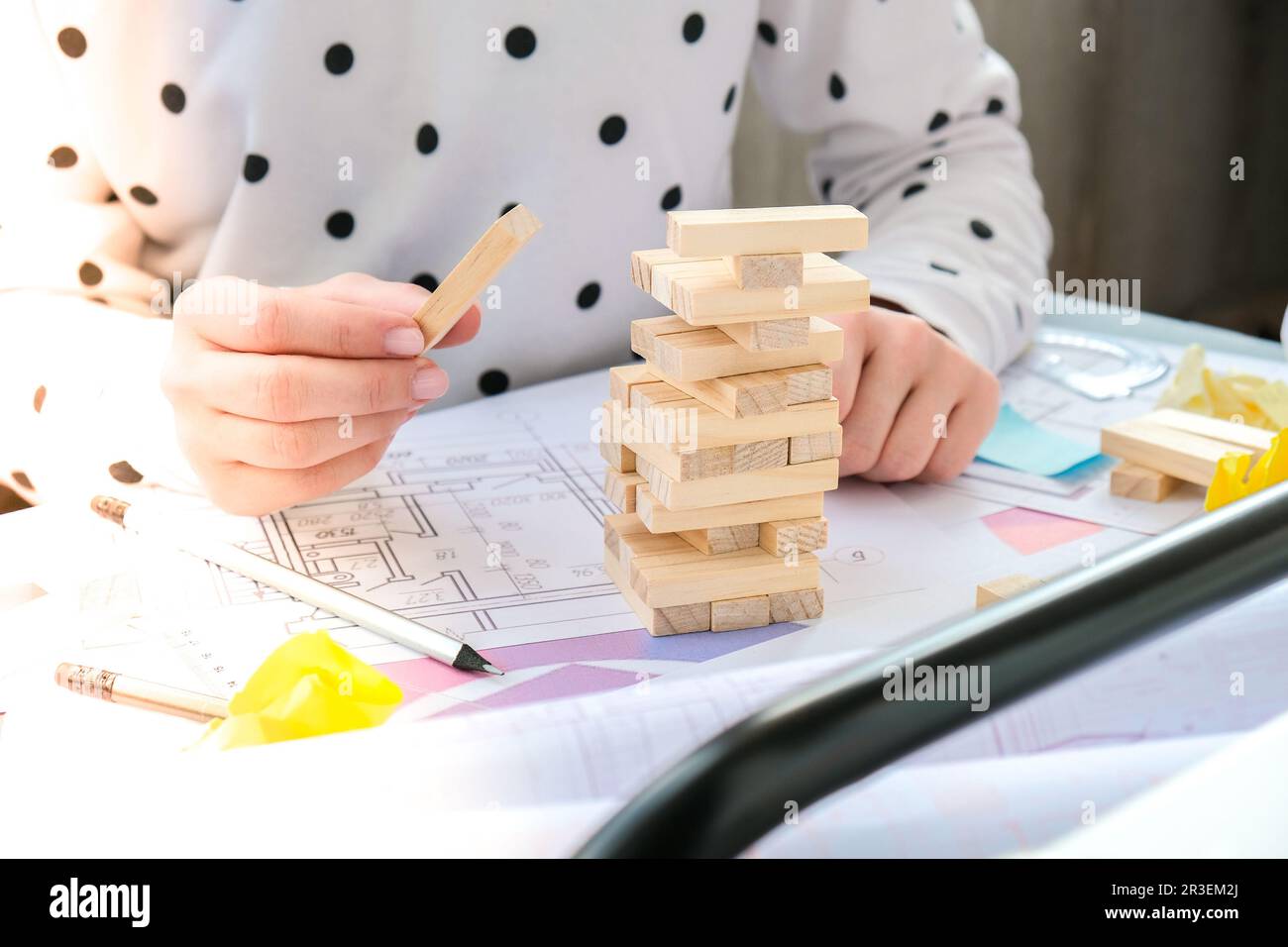 Architecte designer intérieur créatif travail main jouant un jeu de bois de bloc sur le bureau plan architectural de la maison, un PAL de couleur Banque D'Images