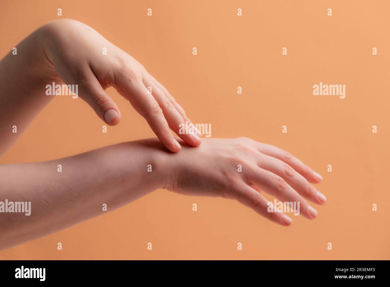 Jeunes femmes mains appliquant de la crème ou de la lotion Banque D'Images