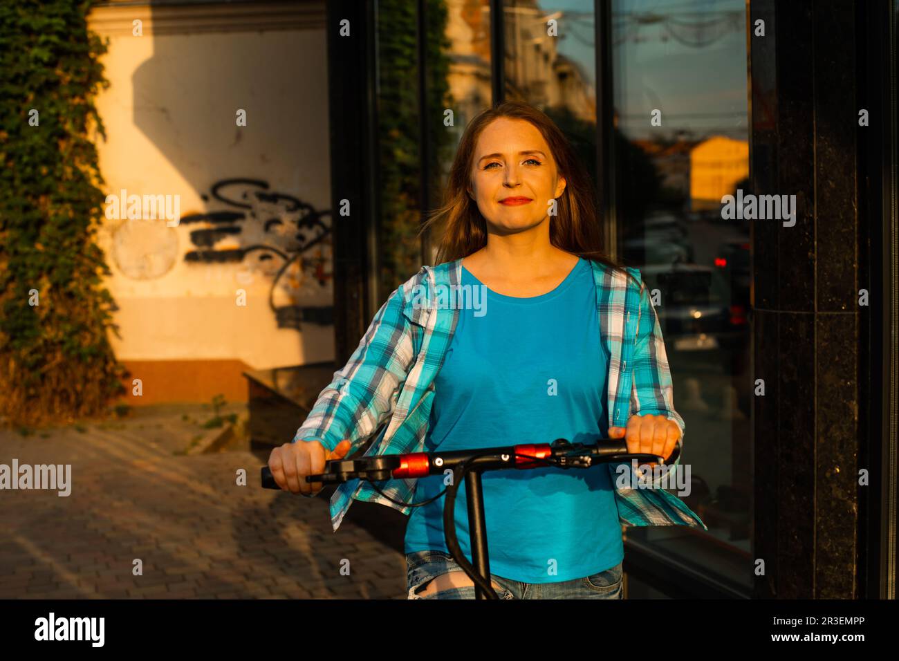 Le jeune homme avec un scooter pose dans la ville Banque D'Images