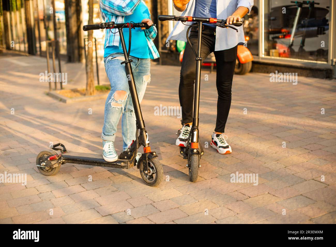 Le couple aimant de conduire un scooter électrique et de regarder l'un l'autre Banque D'Images
