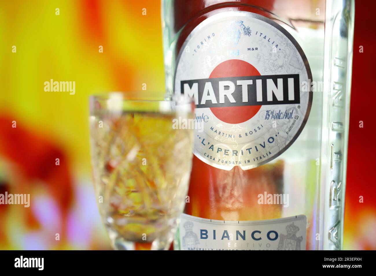 KIEV, UKRAINE - 4 MAI 2022 Vermouth Martini bouteille d'alcool originale sur table en bois avec cheminée rouge sur fond. Production d'alcool élite Banque D'Images