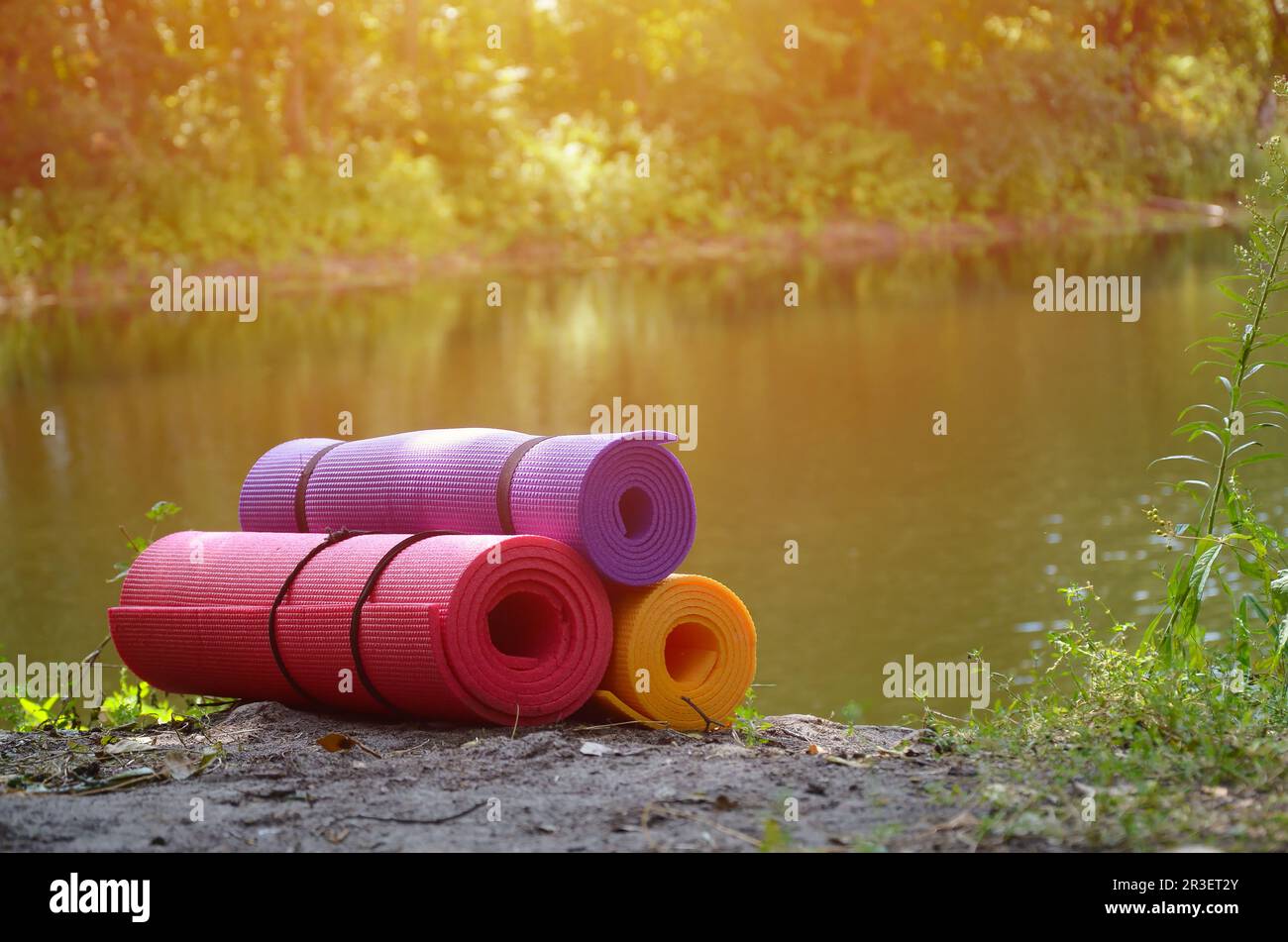 Yoga, fitness ou tapis de tourisme sur l'herbe verte à l'extérieur près de la rivière et de la forêt. Tapis pour le sport dans le bois. Tapis de tourisme Banque D'Images