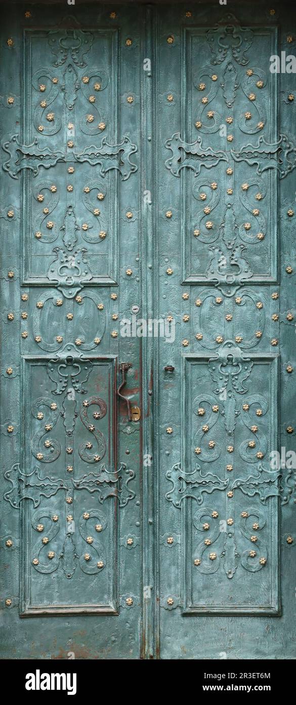 Ancienne texture de porte en métal dans le style médiéval européen. La texture détaillée de la porte vieillie fermée à partir de panneaux métalliques altérés et tachés Banque D'Images