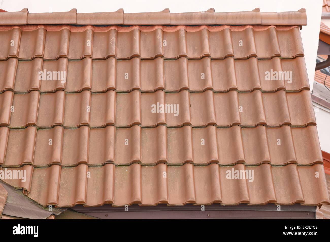 Arrière-plan architectural texturé de carreaux de toit en métal brun. Toit d'une maison avec tuiles modernes de toit en métal Banque D'Images