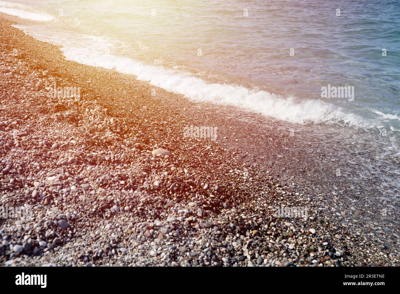 Banque de galets avec la mer et la plage en arrière-plan. Galets et eau sur la rive de la mer à Kemer, Antalya en Turquie Banque D'Images