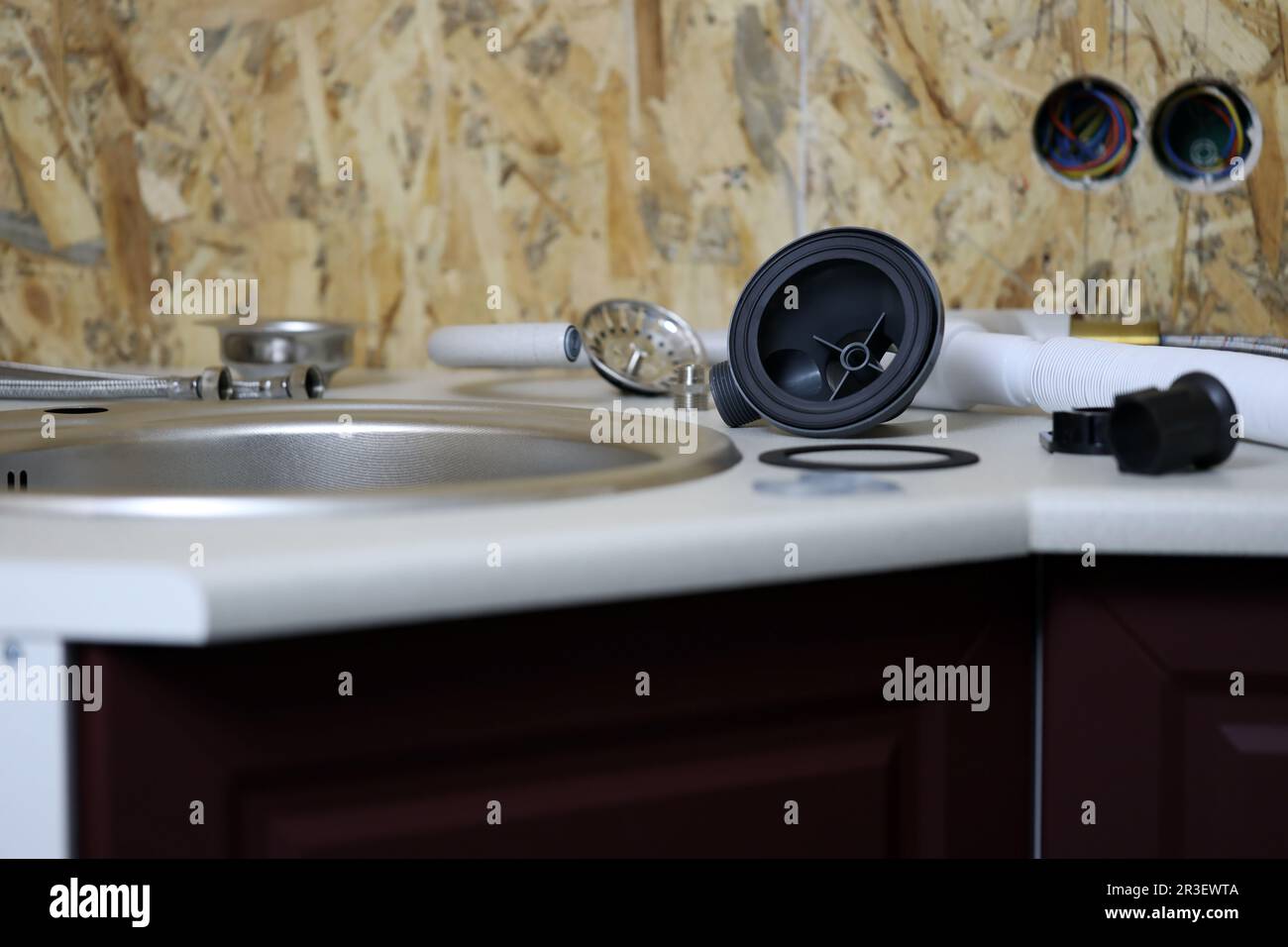 Plombiers outils et robinet d'eau prêts à être installés près de l'évier sur le plan de travail dans la cuisine. Raccords pour l'installation du robinet d'eau pour l'évier de cuisine Banque D'Images