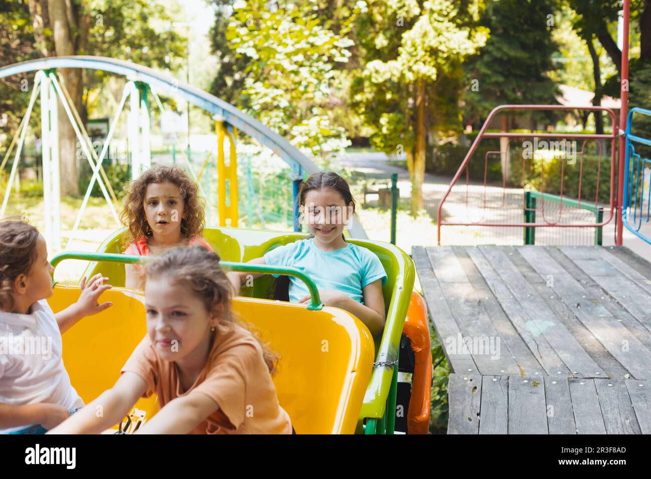 Les enfants heureux sur une montagne à roulettes dans le parc d'attractions Banque D'Images