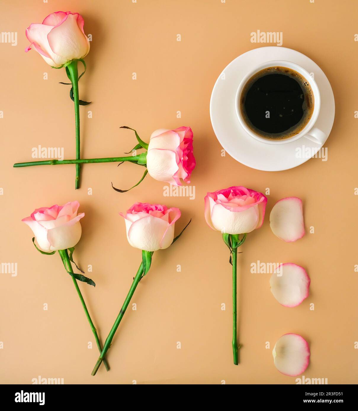 Mot AMOUR fait de fleurs roses rose tendre et tasse de café sur fond beige. Concept d'amour. Pose à plat. Composition minimale. ROM Banque D'Images