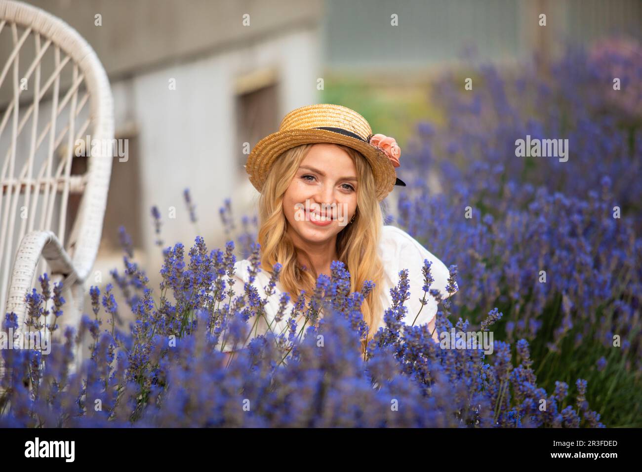 Belle fille blonde dans le chapeau près des arbustes de lavande Banque D'Images