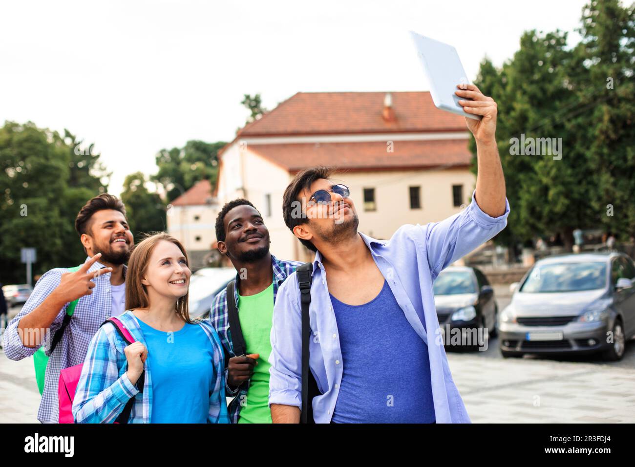Le groupe joyeux d'étudiants multiethniques prenant un selfie à l'extérieur Banque D'Images