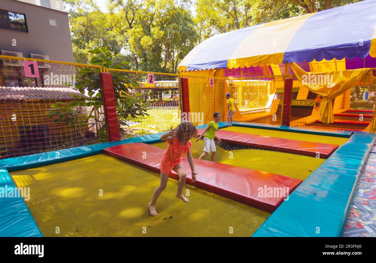 Les enfants joyeux sautent dans le parc du trampoline Banque D'Images