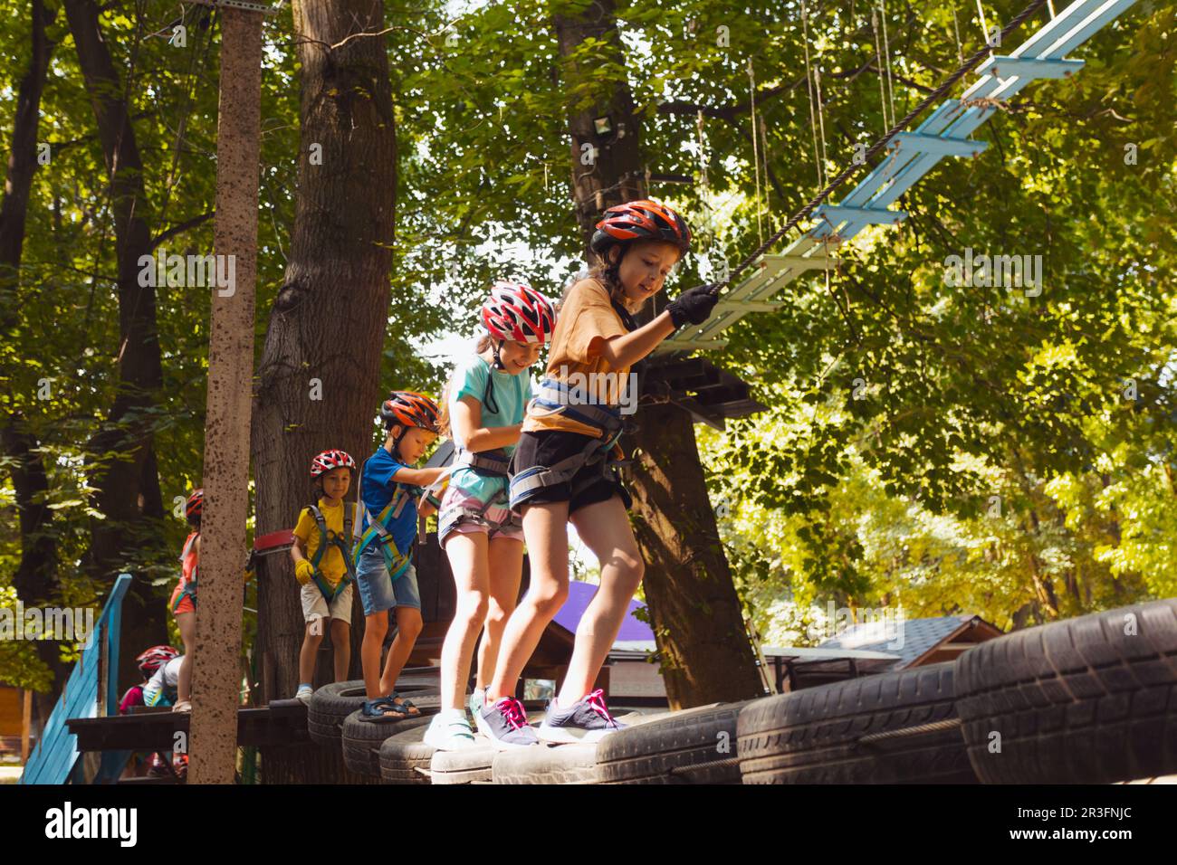 Les enfants surmontent des obstacles dans le parc à cordes Banque D'Images