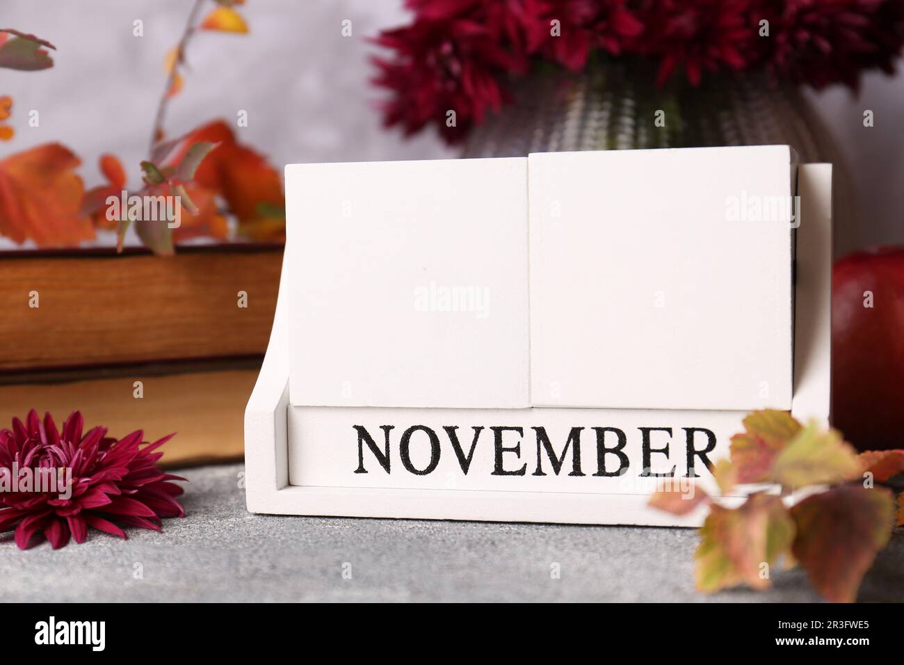 Jour de Thanksgiving, fête célébrée chaque quatrième jeudi de novembre. Bloquez le calendrier et les feuilles d'automne sur la table grise, gros plan Banque D'Images