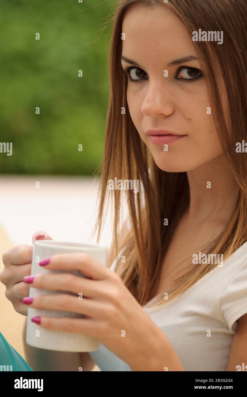 Mujer joven bebiendo de una taza, islas baleares, Espagne. Banque D'Images