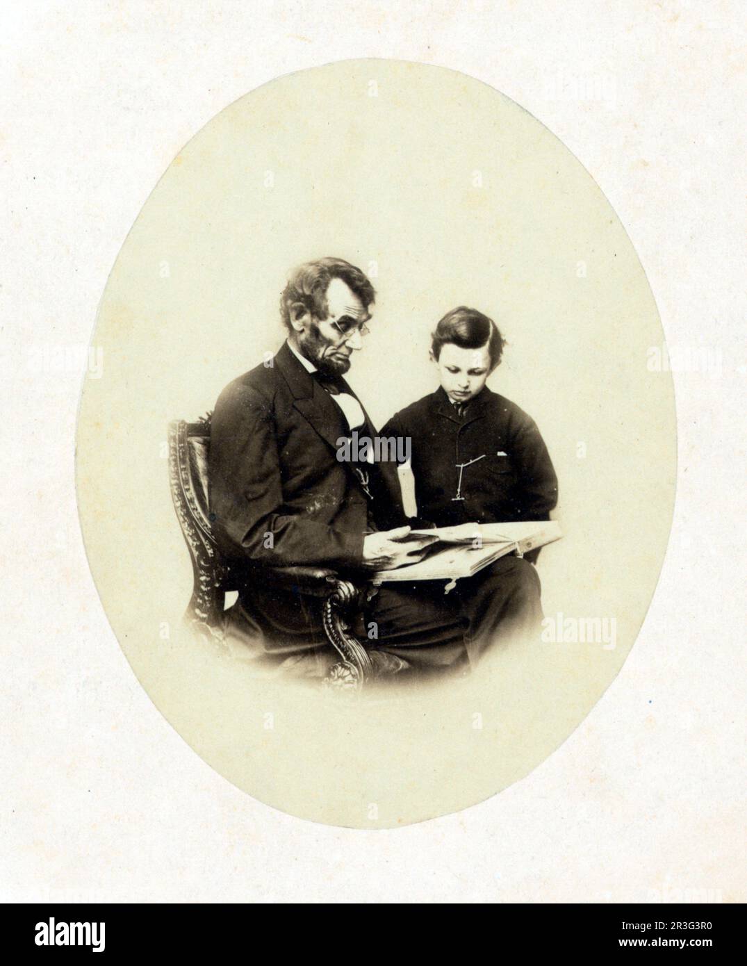 Abraham Lincoln, regardant un album photo avec son fils, TAD Lincoln, 1864. Banque D'Images