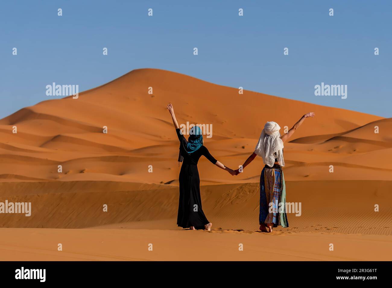 Un beau modèle pose dans les dunes de sable dans le désert du Grand Sahara au Maroc, en Afrique Banque D'Images