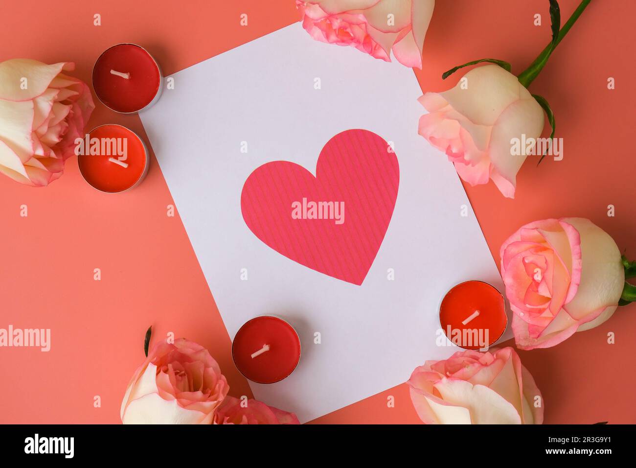 Carte de vœux en forme de coeur sur note papier. Roses roses délicates sur fond rose. Composition tendance minimale. Rose pastel romantique Banque D'Images