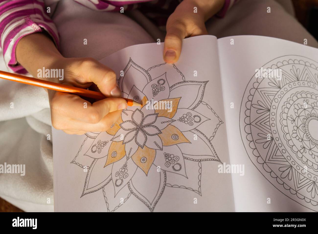 Femme peinture mandalas antistress page pour combattre le stress. Détente passe-temps bien-être mental et art thérapie. Femme peint croquis, Banque D'Images