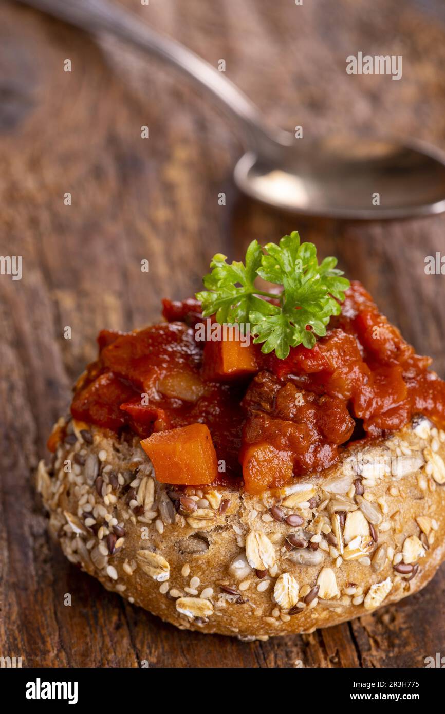 Goulash dans un petit pain sur bois sombre Banque D'Images