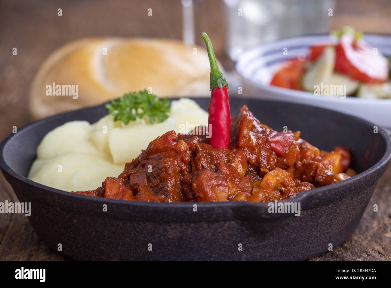 Goulash dans une poêle sur bois sombre Banque D'Images