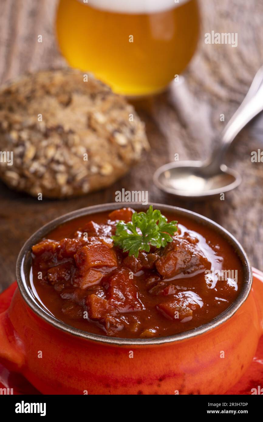 Goulash sur bois sombre avec bière Banque D'Images