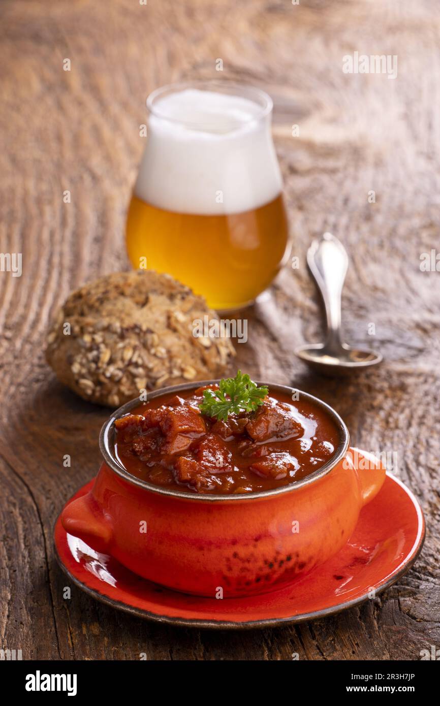 Goulash sur bois sombre avec bière Banque D'Images