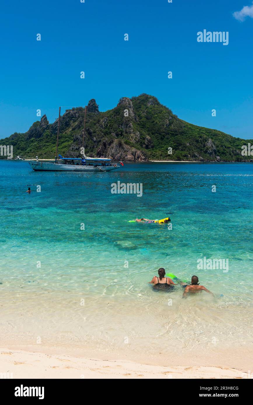 Touristes appréciant les belles eaux turquoise claires de l'île Monuriki ou Cast Away, îles Mamanuca, Fidji Banque D'Images