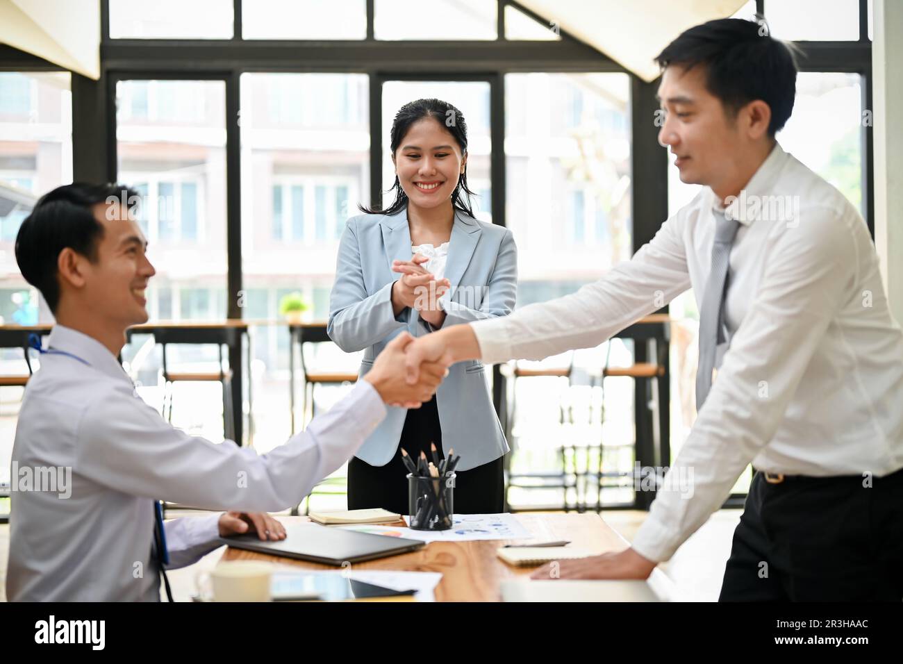 Un homme d'affaires ou un employé de bureau professionnel du millénaire en Asie qui se fait la main avec son collègue et qui souhaite la bienvenue à un nouveau collègue. Concept de travail d'équipe Banque D'Images