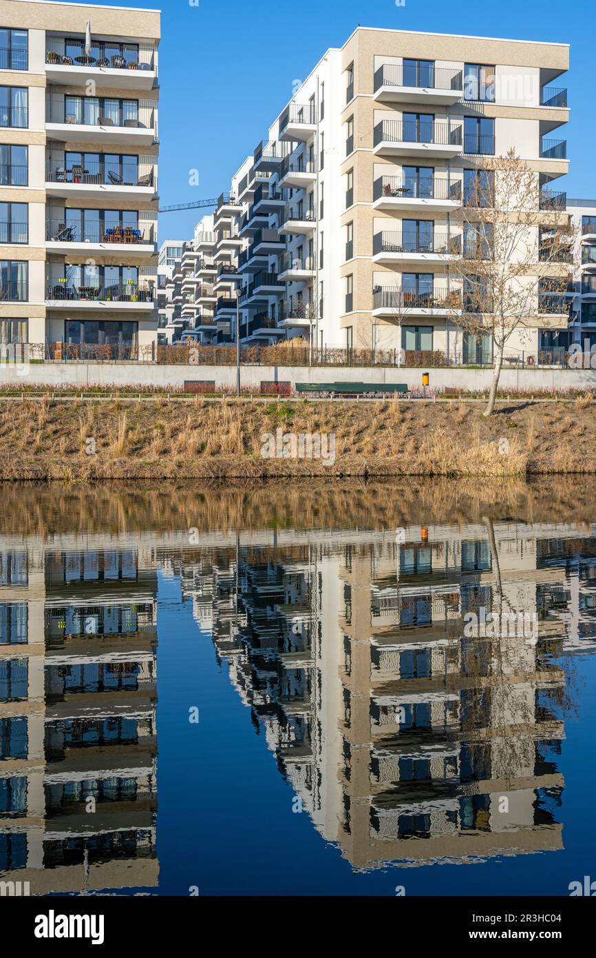 Nouveaux immeubles d'appartements avec un reflet parfait dans un petit canal vu à Berlin, Allemagne Banque D'Images