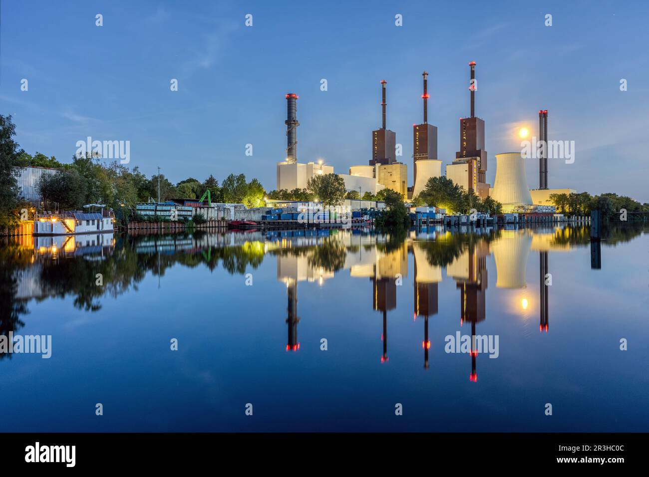 Une centrale thermique et électrique combinée à Berlin la nuit avec une parfaite réflexion dans l'eau Banque D'Images
