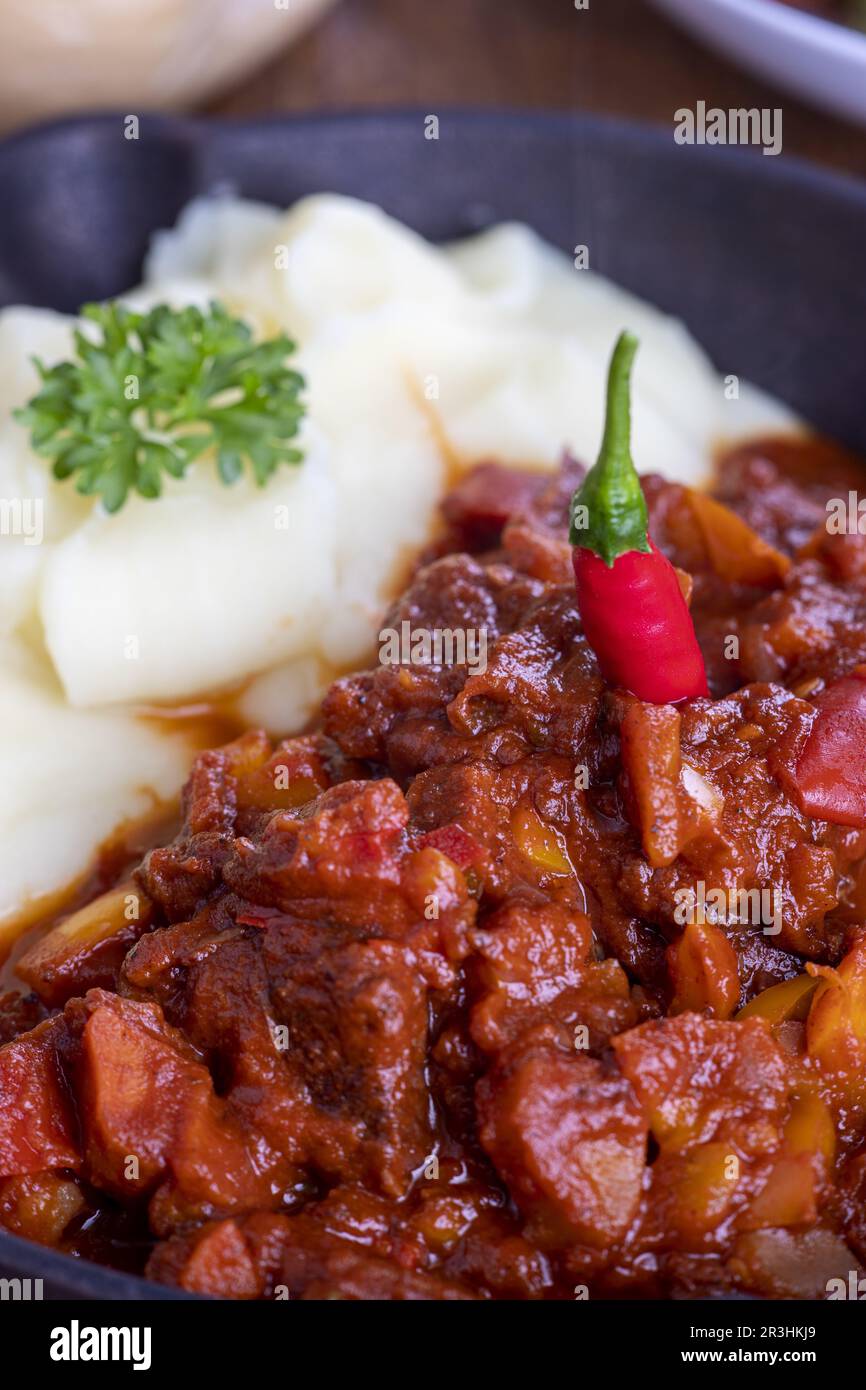 Goulash dans une poêle sur bois sombre Banque D'Images
