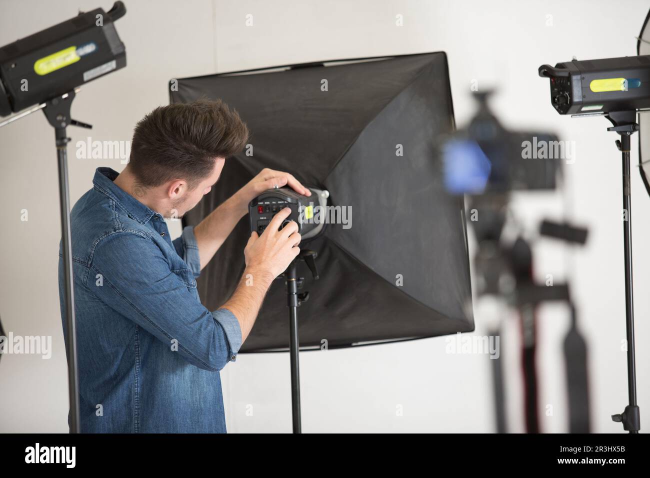 le photographe définit le minuteur sur le boîtier lumineux en studio Banque D'Images