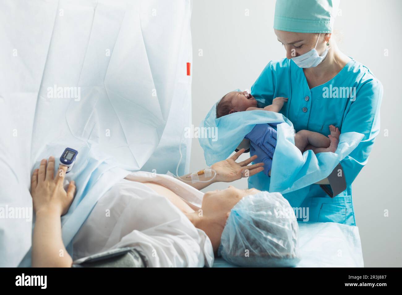 L'infirmière garde le nouveau-né près de la mère à l'hôpital Banque D'Images
