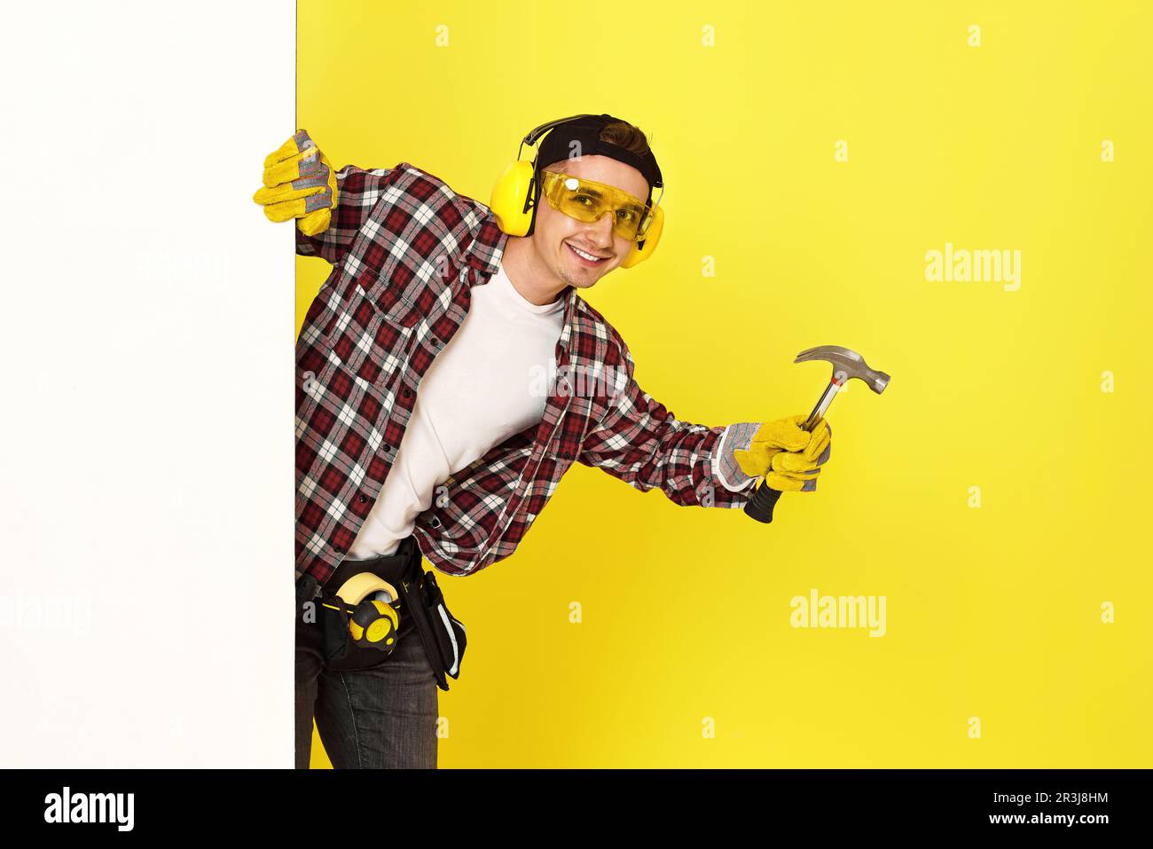 constructeur professionnel de vêtements de travail dans un casque tenant un marteau. Banque D'Images