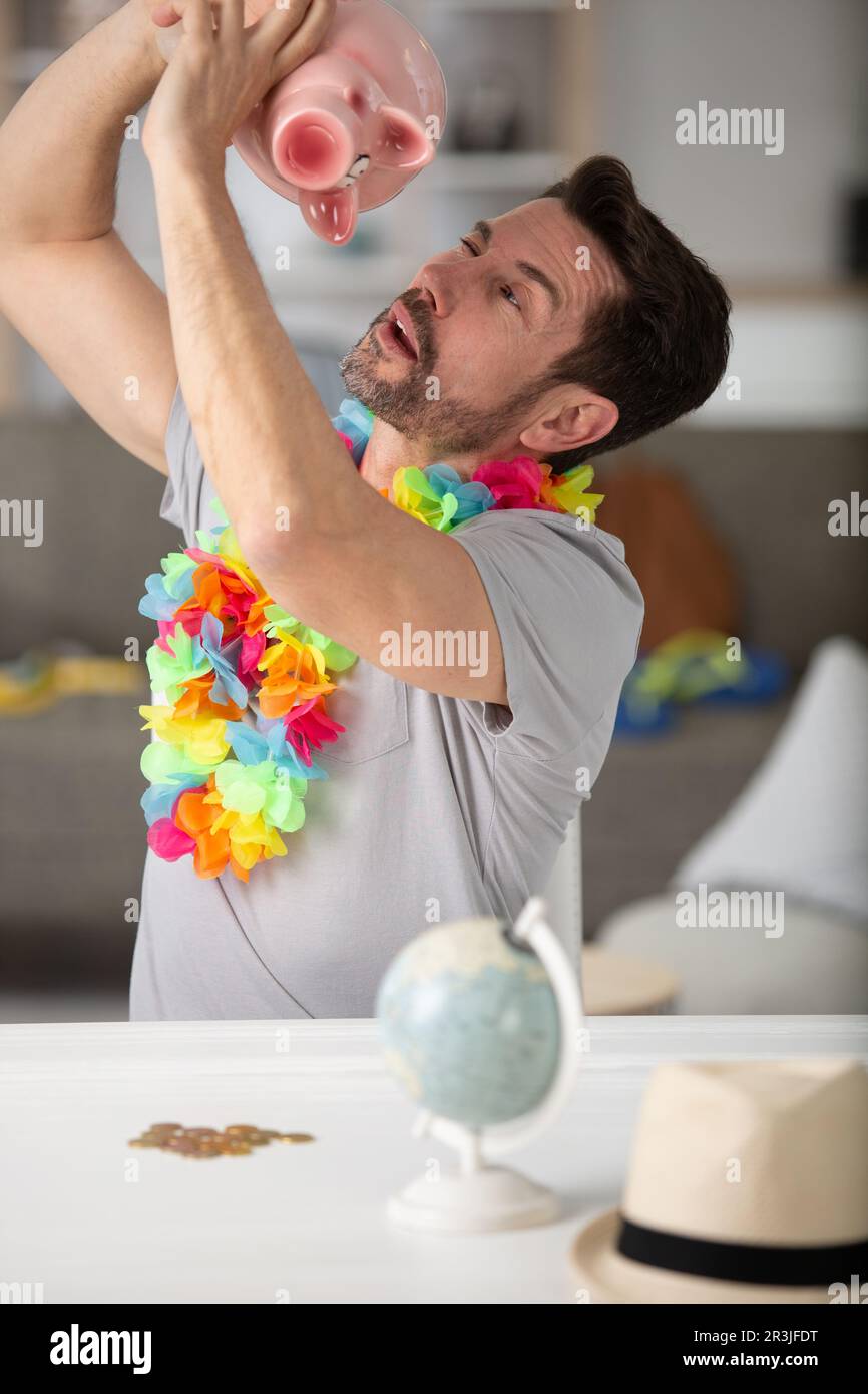 homme tenant une banque de pigey essayant de sortir de l'argent Banque D'Images