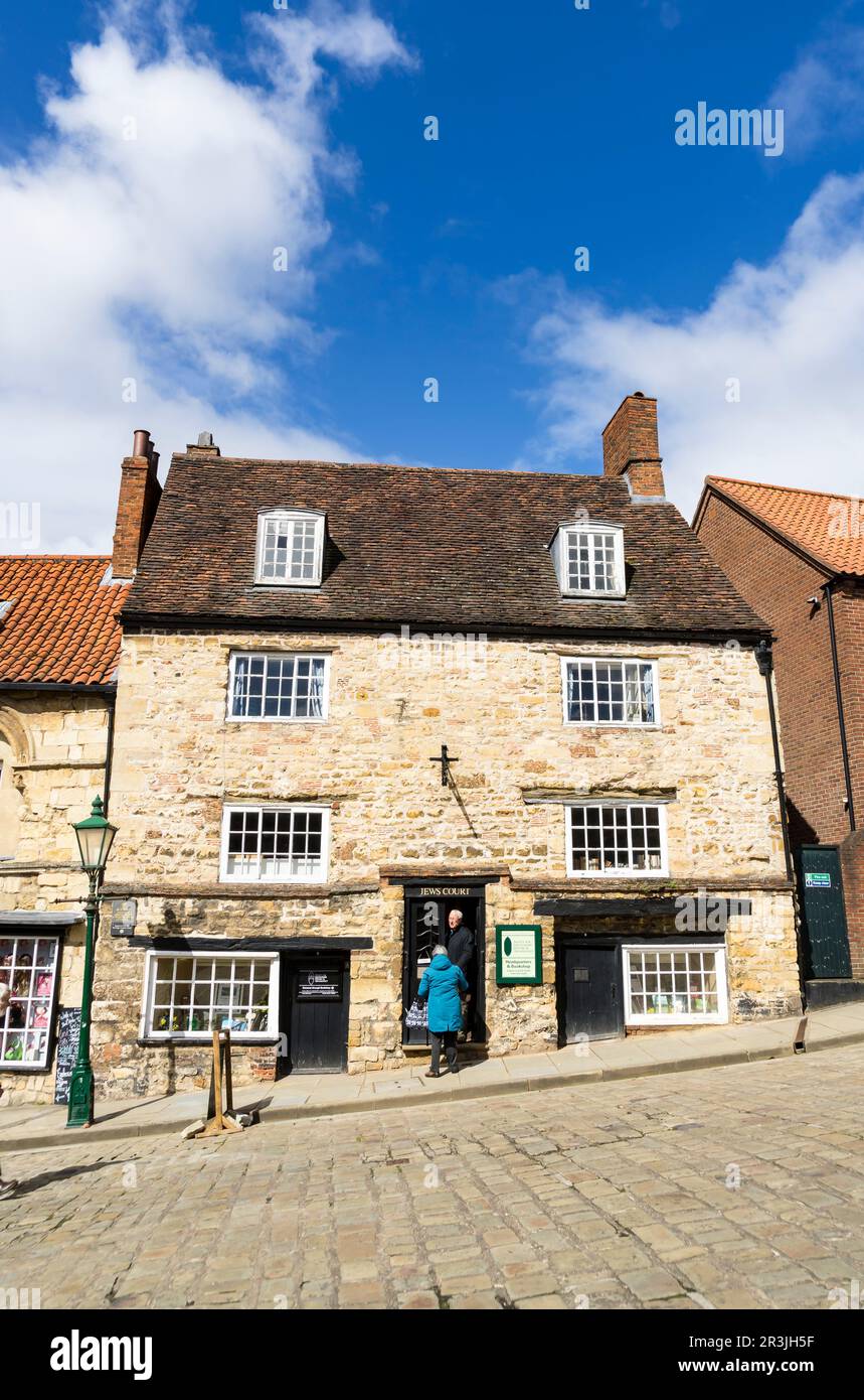 Les gens qui entrent dans la boutique de livres de Judaïsme court trois étages pierre à chaux bâtiment Steep Hill Lincoln City, Lincolnshire, Angleterre, Royaume-Uni Banque D'Images