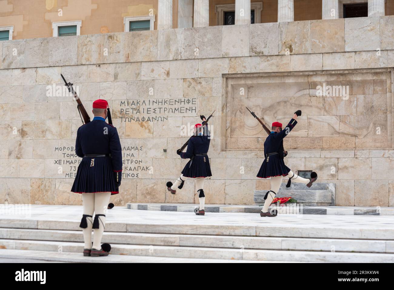 Le texte sur le mur et un lit reste vide pour l'inconnu en grec et en grec Evzone soldats en costumes traditionnels Banque D'Images